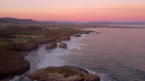 Aerial drone sunset view of cliff rock formation over the ocean seascape, meditative relaxing peace