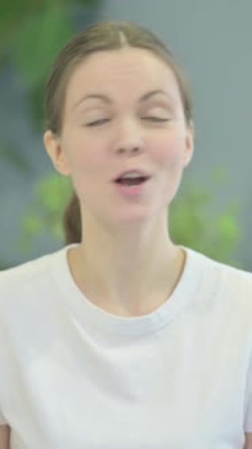 Smiling Woman Waving and Talking to Camera