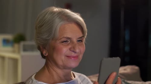 Attractive Senior Woman Using Mobile Phone at Home