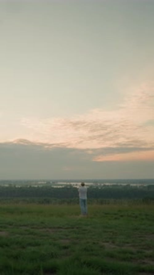 Contemplative Man in a Tranquil Landscape By the Lake at Sunset
