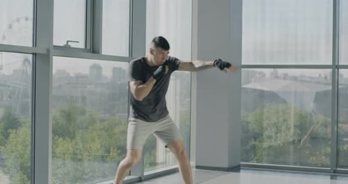Slow Motion of Young Sportsman with Wrapped Hands Training Boxing Moves Enjoying Martial Arts in Gym