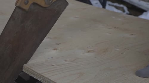 The Cutting Of Wood Plank By Moving The Hand Saw Up And Down. -close up shot