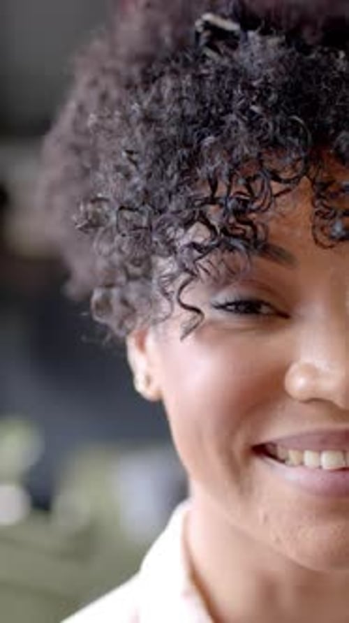 Vertical video of portrait of smiling african american businesswoman in office with copy space