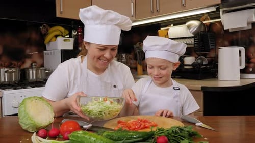 Woman and Child Preparing Salad Together in Kitchen