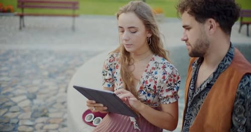 Stylish Couple Using a Tablet in an Urban Park