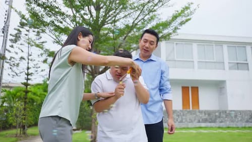 Asiatische attraktive Familie, Eltern spielen mit kleinem Sohn im Garten.