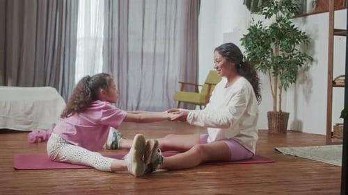 Mother and Daughter Stretching Together at Home