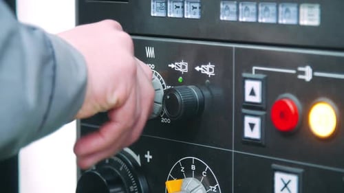 Drehbarer Einstellknopf eines Ingenieurs an einer Industriemaschine. Menschliche Hand, die die Maschine verwaltet, eingeschaltet