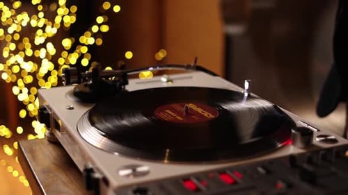 A DJ plays music on vinyl records. Close up