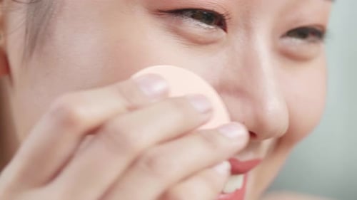 Close Up Of Asian Woman Applying Powder Face For Wellness Skin Care And Smiling While Wearing Makeup