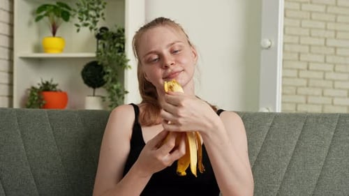 Woman Enjoys Healthy Banana Snack on Couch