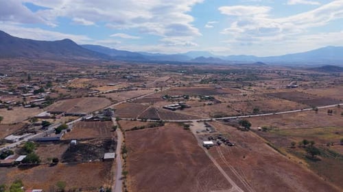 Panoramic Aerial View of Dry Rural Farmland and Distant Mountains