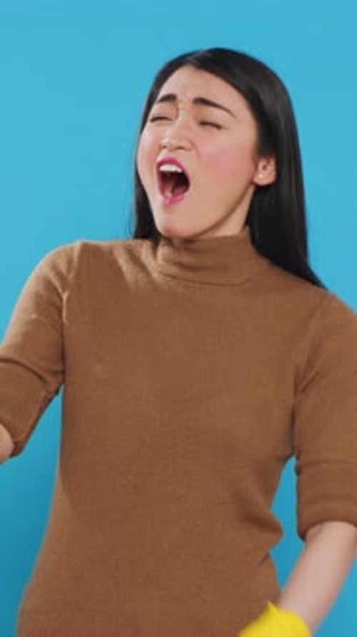 Woman Yawning with Cleaning Gloves and Duster
