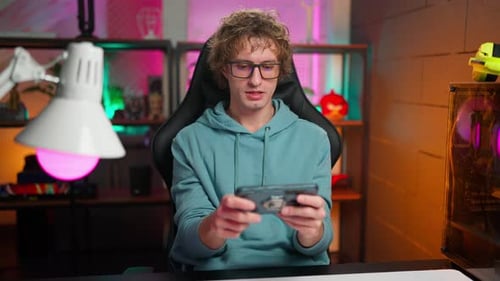 Young Adult Male Playing Game on Smartphone