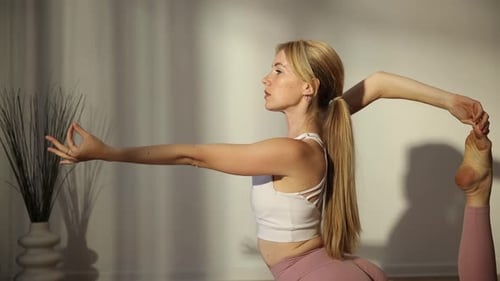 Blonde Woman Practices Yoga Pose Indoors