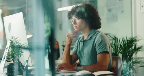 Thinking, online and programming in office, man and IT specialist with glasses, computer or serious