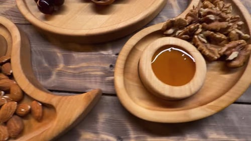 Nuts, Grapes, and Honey on Wooden Trays