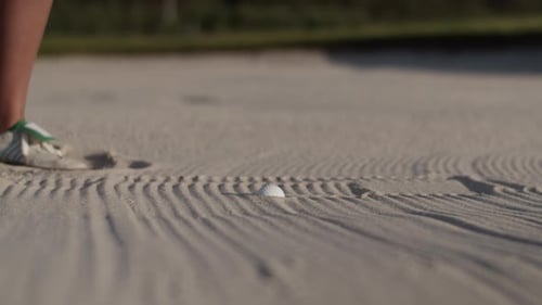 Woman Golfer Executes Shot Launching Golf Ball From Sandy Bunker