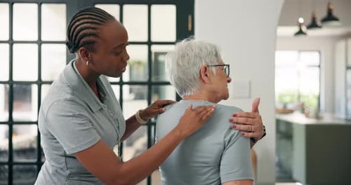 Woman Receives Shoulder Massage from Caregiver Indoors