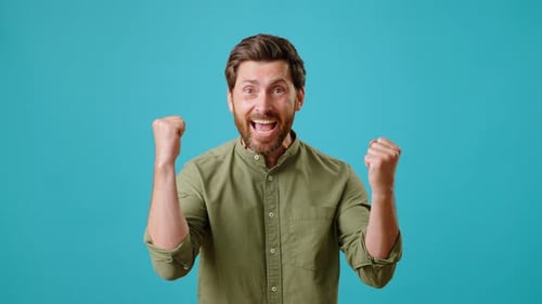 Excited Man Celebrates Success on Teal Background