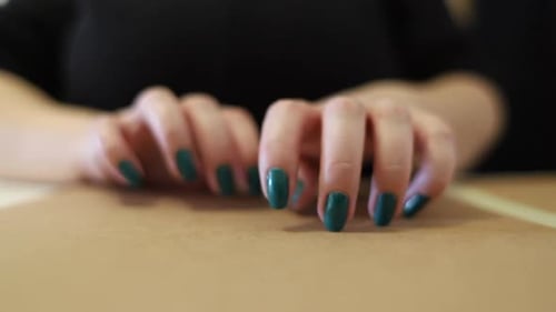 Female long nails tapping on hard surface. Fast and slow hand movements. Green painted Nails