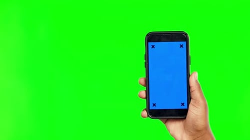 Person, hands and phone mockup on green screen for advertising against a studio background