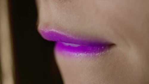 Fashion Model Lips/Purple Lipstick on Girl Lips/Woman Bites Lip/Sexy Female Mouth Close