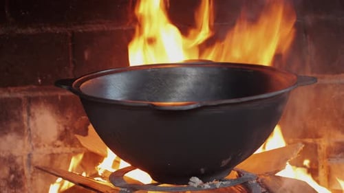 Cauldron Over Open Fire in Brick Fireplace