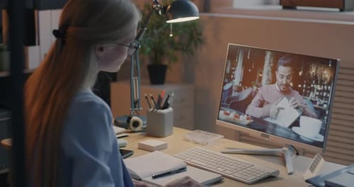 Businesswoman Making Online Video Call Talking to Middle Eastern Man Using Computer in Dark Office