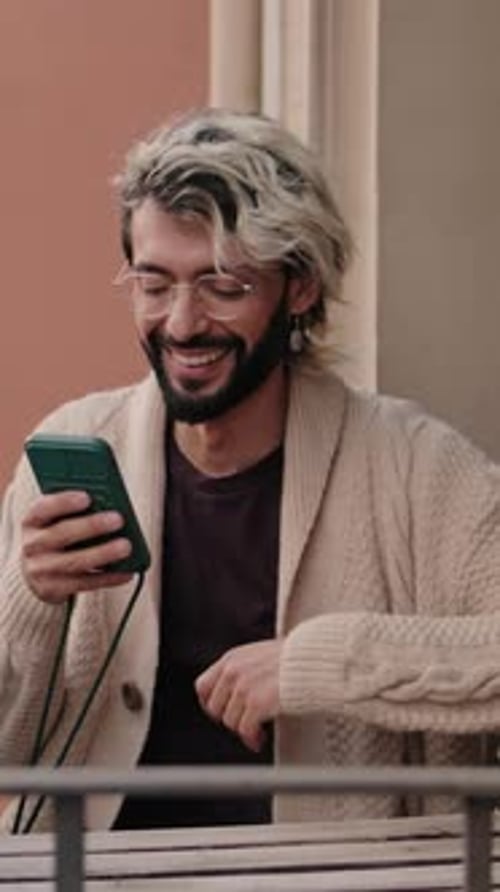 Vertical video, Gay Couple at Home on Balcony With Smartphone