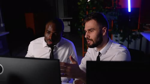 Two Traders Analyzing Financial Data on Computer Screens