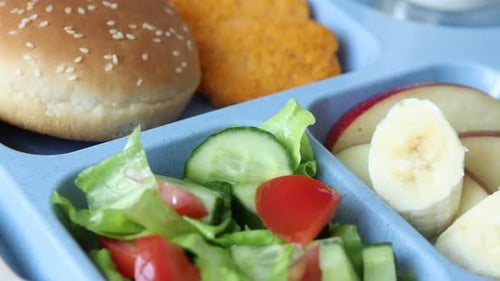 Déjeuner scolaire. Plateau en plastique avec de la nourriture savoureuse, du lait et une fourchette sur une table en bois, gros plan
.