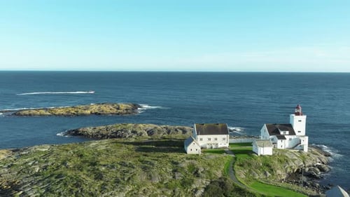Ein wunderschöner Leuchtturm steht auf einer felsigen Insel, die vom Meer umgeben ist. Helles Sonnenlicht reflektiert