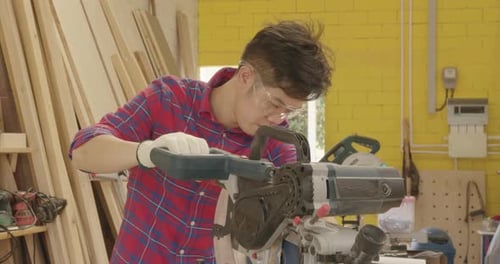 Worker young asian man carpenter building design and cutting wooden