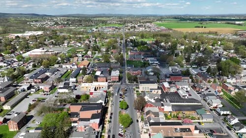 Aerial backwards shot of american town with historic buildings and driving cars. Scenic city of USA