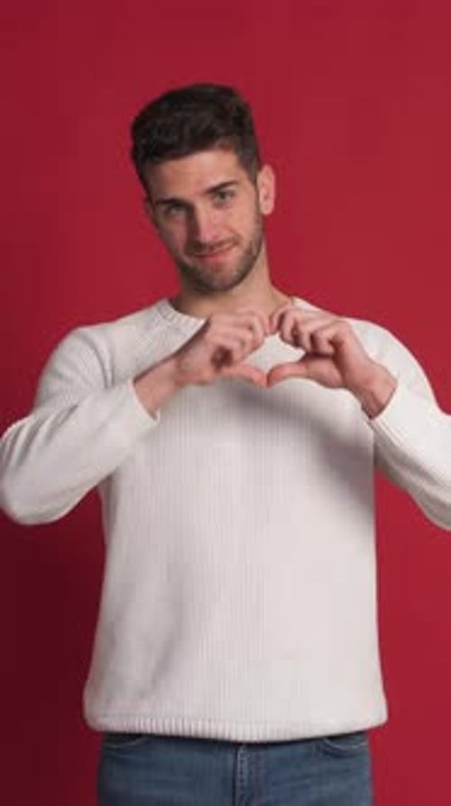 Young Adult Man Makes Heart Gesture