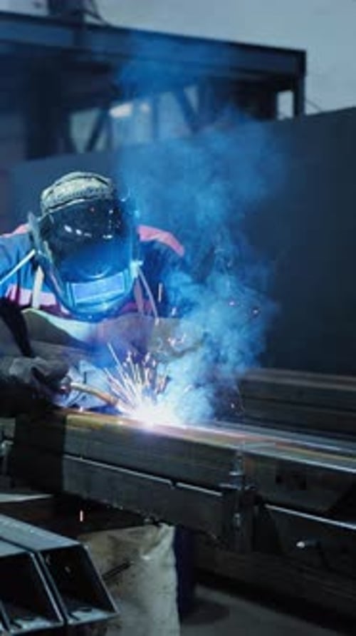 Welder Working on Metal Fabrication in a Workshop