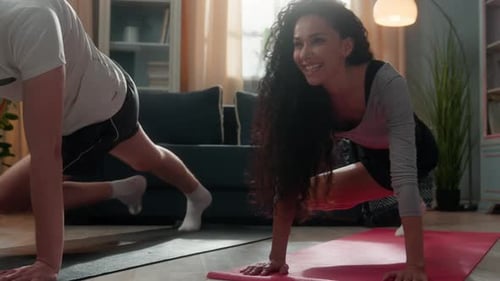 Couple Do Mountain Climber Exercise in Living Room