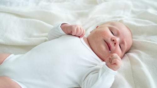 Adorable Infant Lying on White Blanket