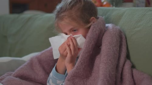 Sick Child Wrapped in Blanket Sneezes