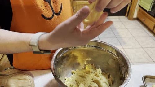 Man hands handling dough into a cookie shape and placing on a cookie sheet, close up"