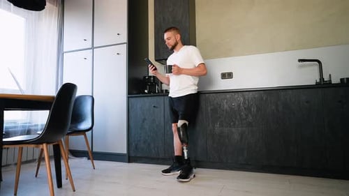 A Man Amputee with Prosthetic Leg Enjoying Coffee And Use Phone After Rehabilitation