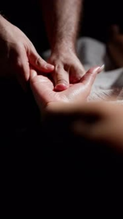 Die Hand eines Mannes massiert sanft die Hand einer Frau mit einer Maniküre Vertikales Zeitlupenvideo Lowkey