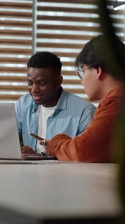 Group of Creative Young People Work on New Project Using Laptop and Graphs in a Friendly Atmosphere