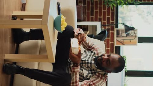 Young Adult Eating Noodles at Home