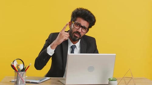 Professional Man Talking at Desk with Laptop