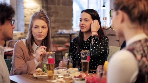 Friends Enjoying Drinks and Food at Cafe