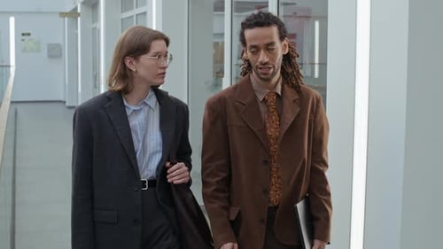 Young Man Discussing Ideas with Female Colleague Walking in Business Center