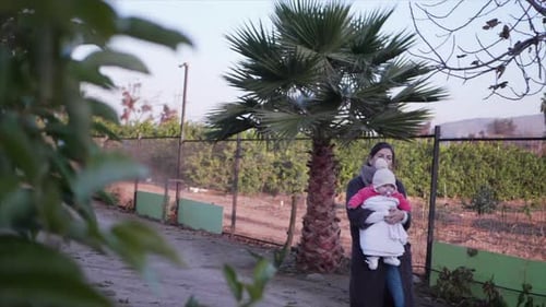 slowmotion of a beautifull mother playing on a orange farm with het little daughter
