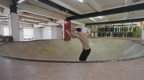 Man Skateboarding in an Indoor Skatepark